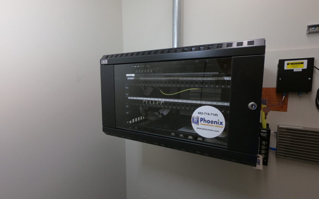 Network rack with cabling and patch panel, showcasing Phoenix Communication Solutions cabling work.